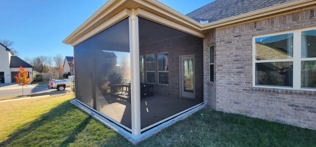 Covered porch with motorized retractable screens lowered on a brick home in Northwest Arkansas