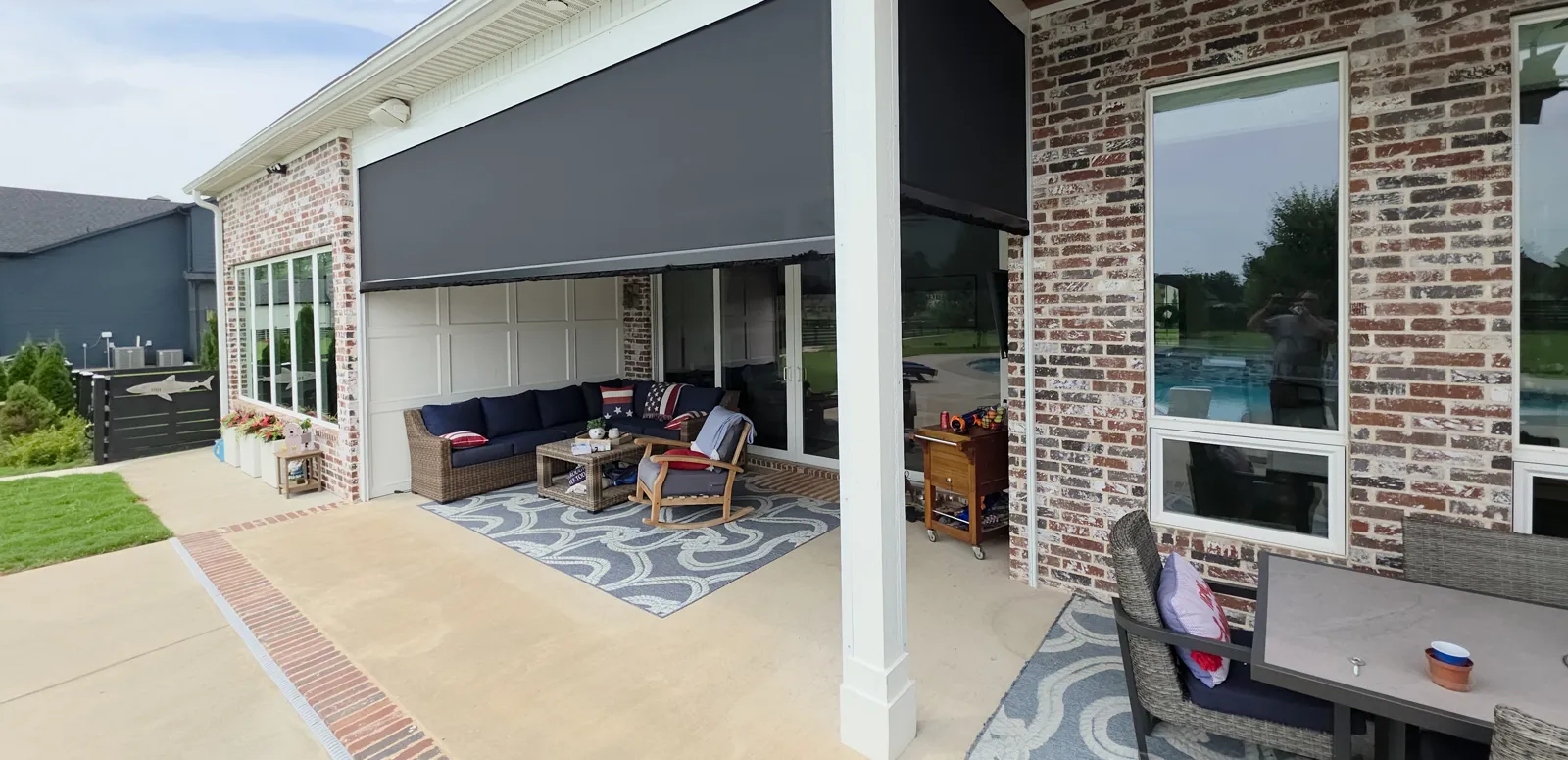 Charcoal screen above a covered patio with a white column on a red and white painted brick house in Averie Estates, Cave Springs, Arkansas