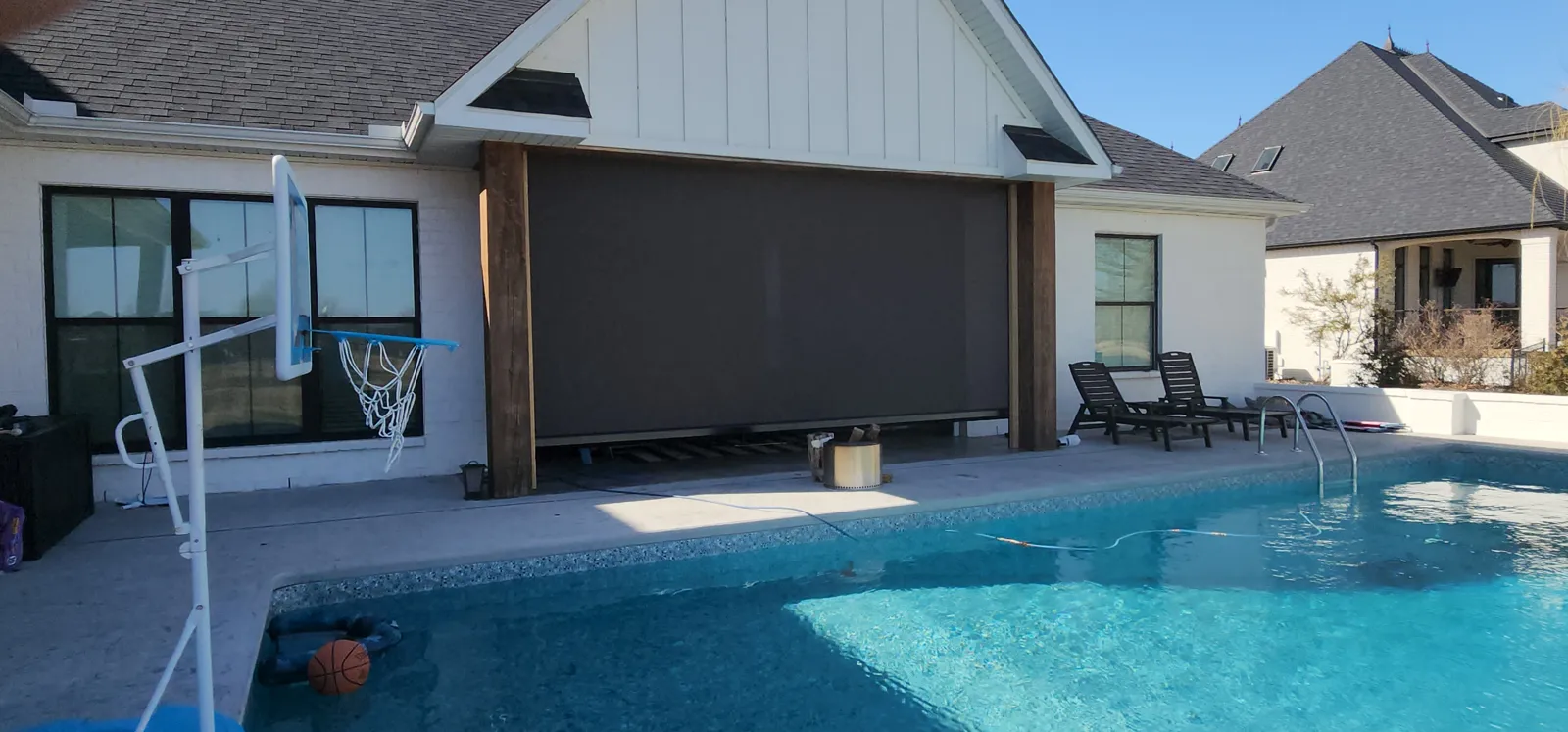 Dark brown screen closed between wood posts on a covered patio beside the pool in Big Creek Estates, Mountain Home, Arkansas
