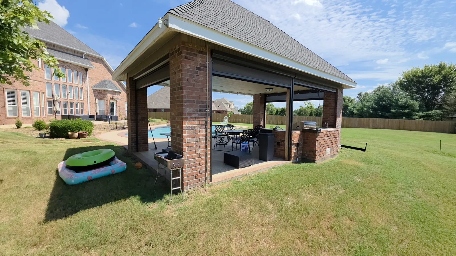 Brick covered patio structure beside the pool and yard in Evening Star, Cave Springs, Arkansas