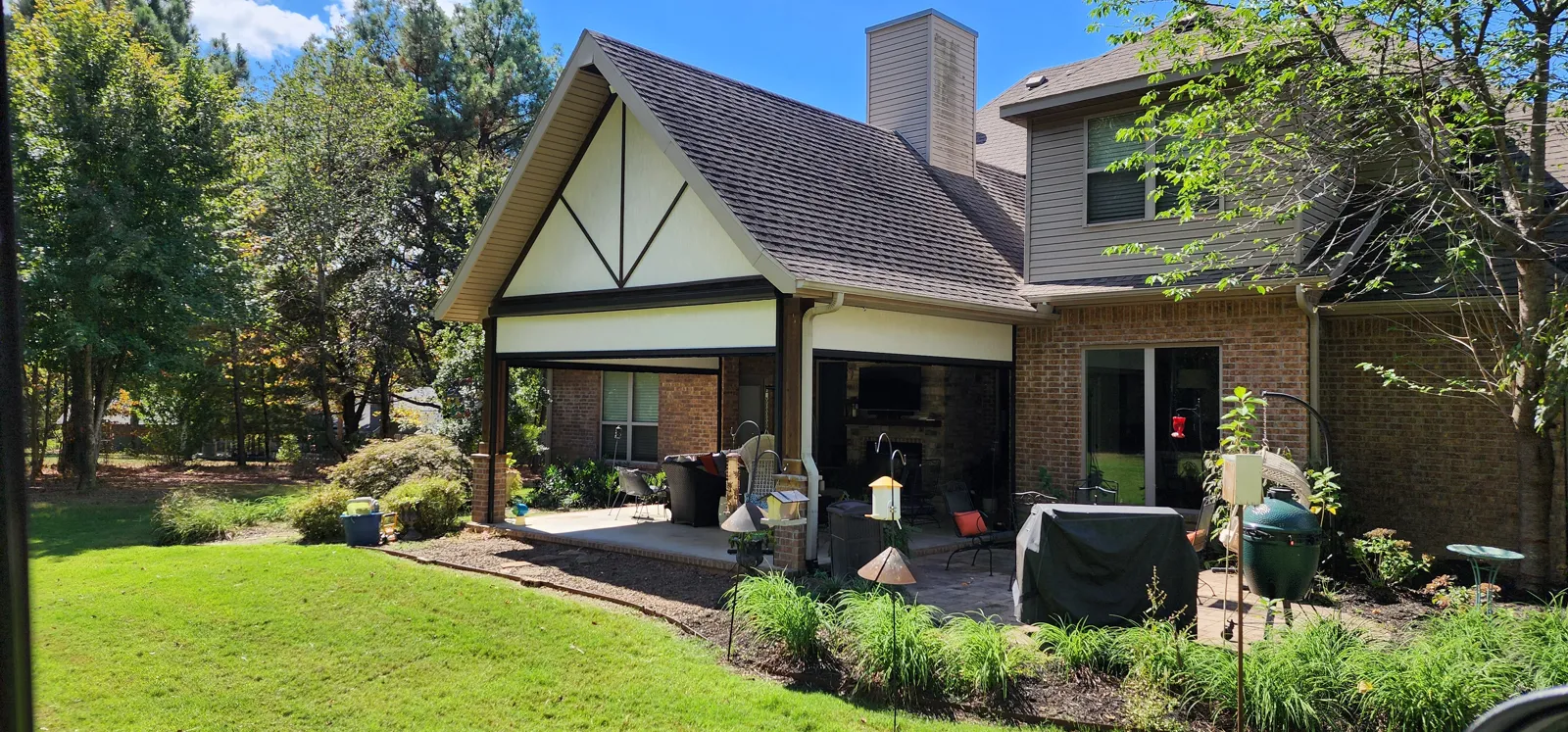 Covered back patio under a gable on a brick house with a landscaped yard in Hartsfield, Fayetteville, Arkansas