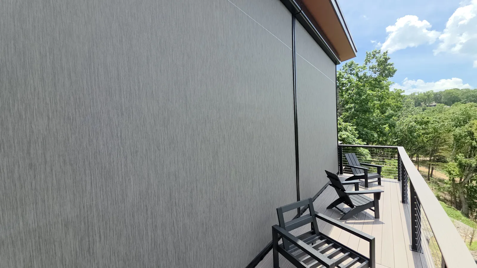 Gray screen closed on an upper deck with cable railing, lake and trees behind in Huckleberry Hills, Rogers, Arkansas