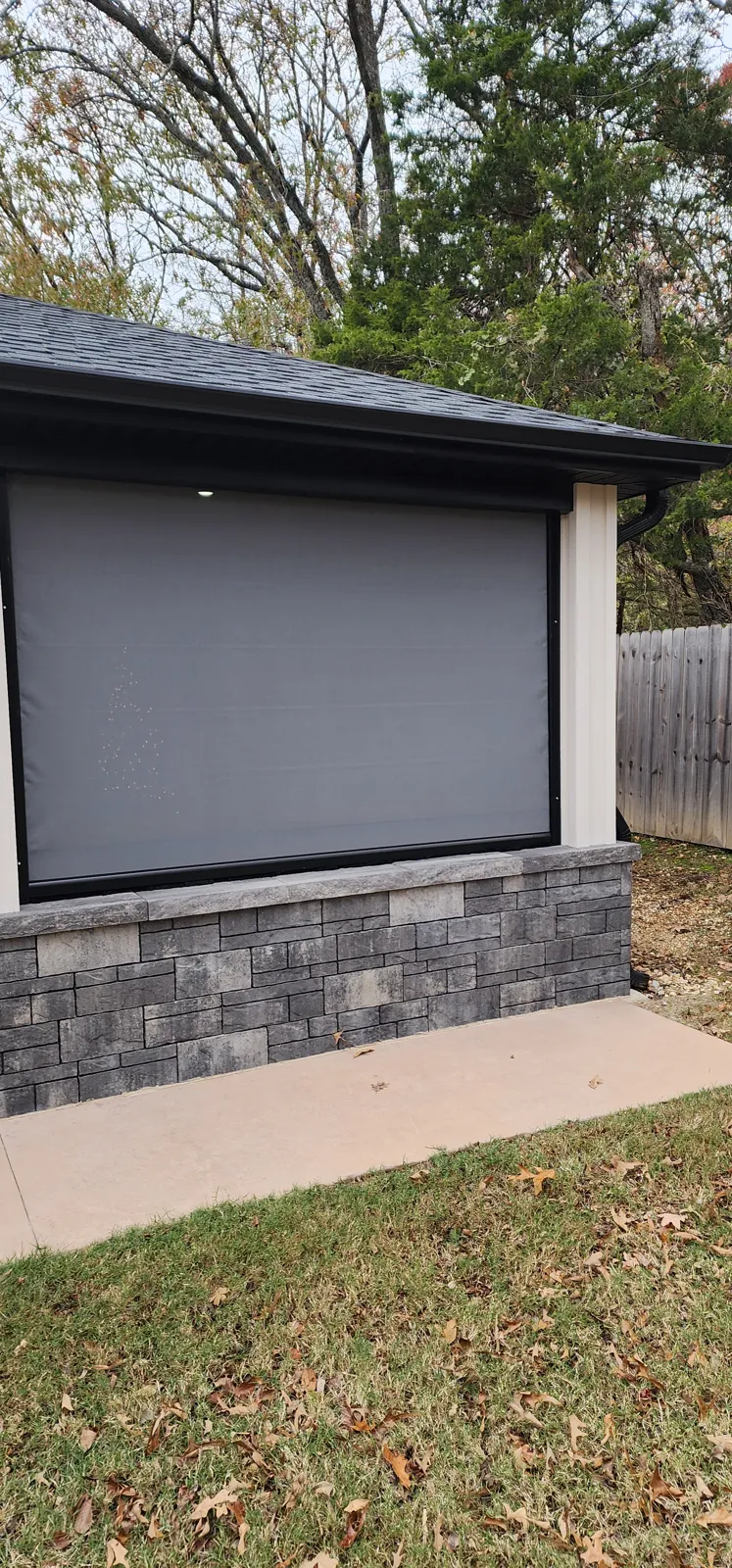 Graphite screen closed on a small covered patio with a stone base in Hughmount Village, Fayetteville, Arkansas