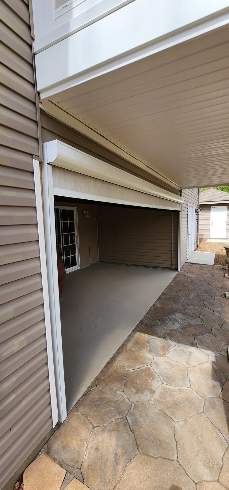 White screen housing tucked under the soffit on a vinyl-sided porch in Lands End, Bella Vista, Arkansas