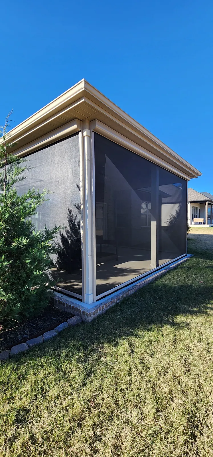 Dark insect-style screen closed on the corner of a covered porch with cream columns in Magnolia Park, Fayetteville, Arkansas