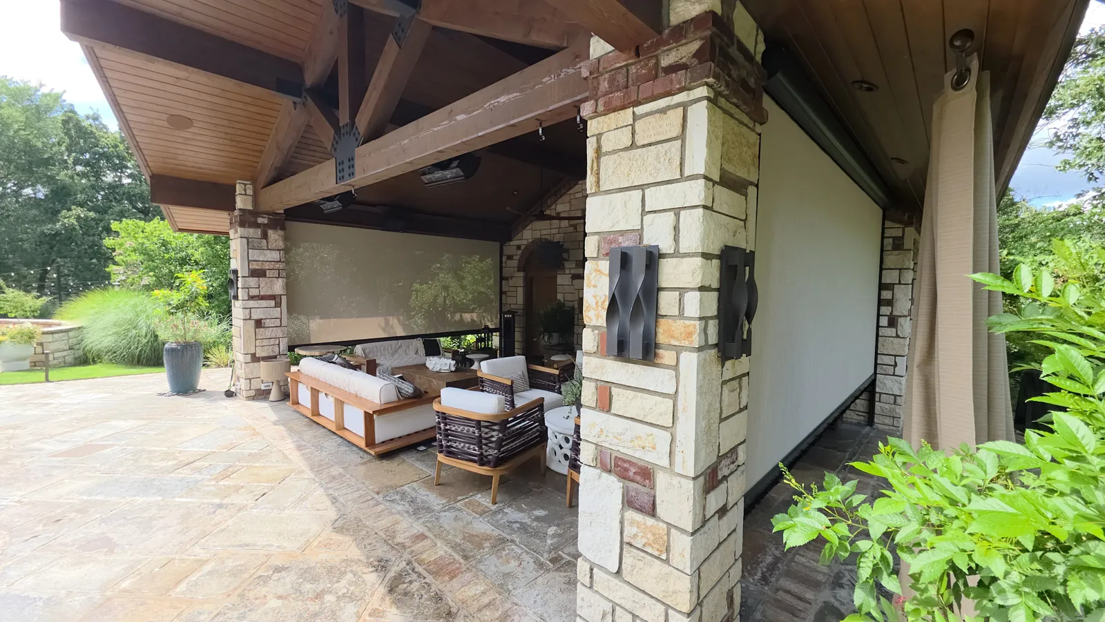 Cream screen closed behind a seating area under a timber and stone pavilion in The Highlands on Riley Farm, Fort Smith, Arkansas