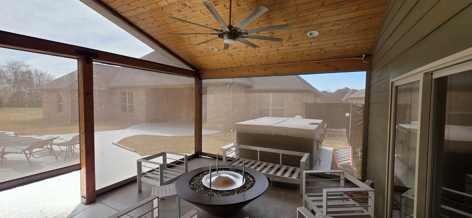 Light see-through mesh across a covered patio with a pine ceiling, fire pit and hot tub in Walnut Grove Acres, Farmington, Arkansas