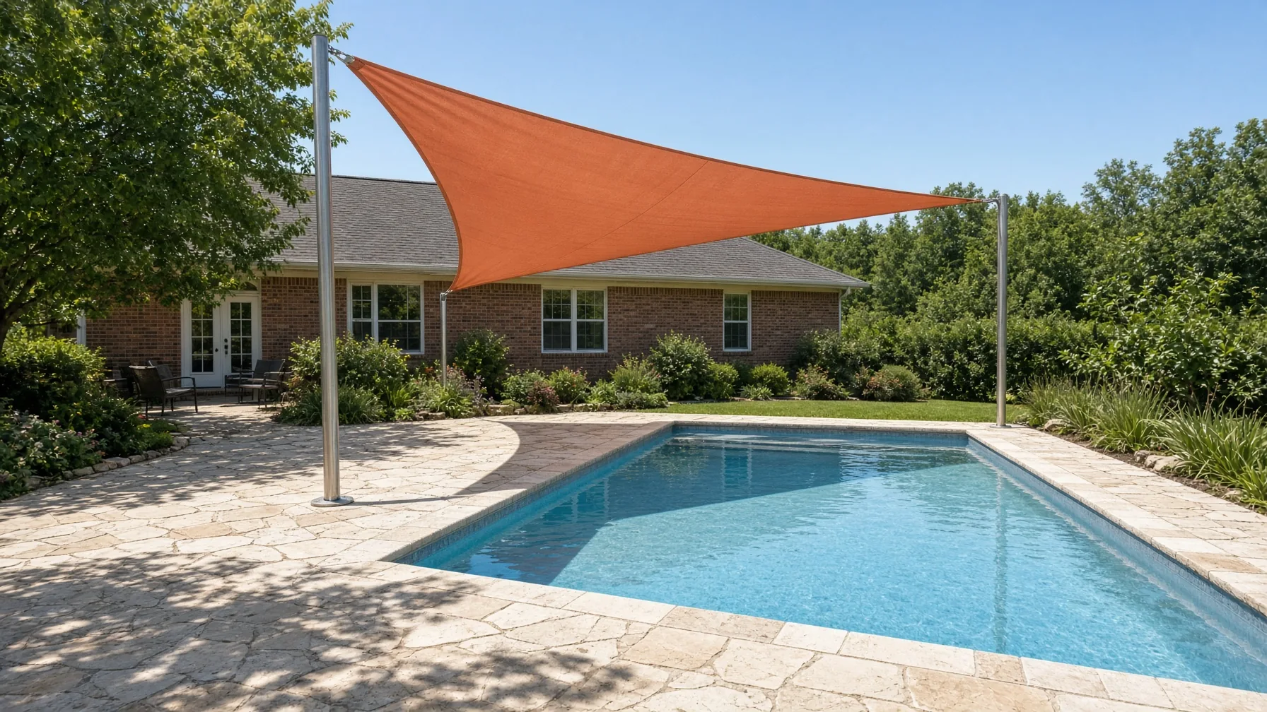 Terracotta triangular shade sail tensioned over a residential pool deck