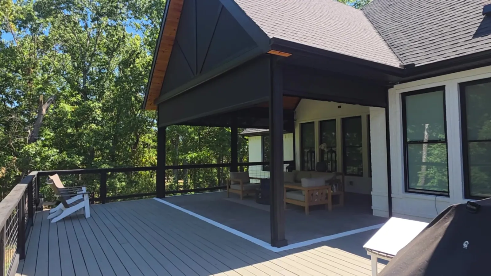 Covered deck in Rogers, Arkansas with the motorized retractable screens fully retracted, cedar gable ceiling and black cable railing, installed by NWA Security Shutters